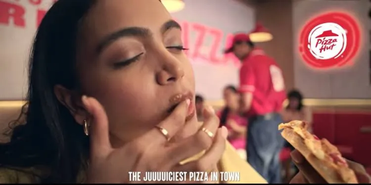 Young woman happily enjoying Pizza Hut's new Juicylicious pizza.